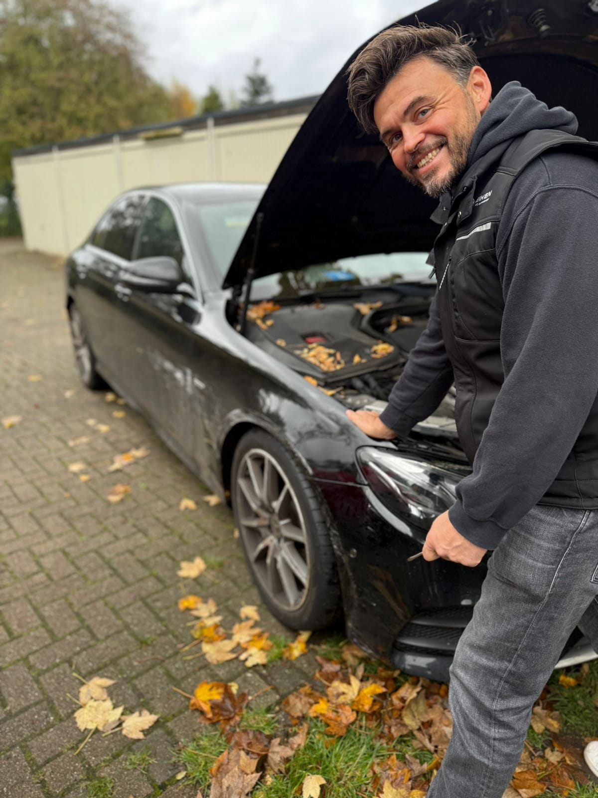 Carsten Heiken begutachtet einen Unfallschaden am Fahrzeug